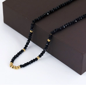 Detail of faceted black rhinestones and gold beads on a luxurious beaded necklace