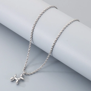 Détail du pendentif chien ballon argenté avec chaîne de corde sur fond minimaliste gris