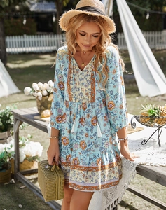 Dettaglio dell'abito floreale boho con scollo a V e orlo a balze in un contesto da giardino
