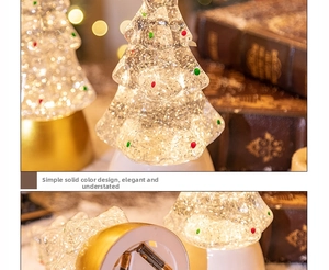 Close-up of a glowing Christmas tree crystal ball with glitter and battery compartment
