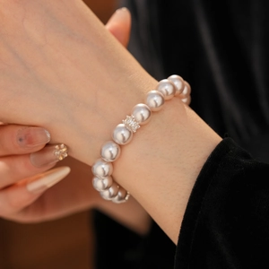 Gros plan d'un bracelet en perles avec incrustation de zircon sur un poignet