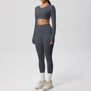 Detail of high-waisted dark grey yoga leggings with side pocket and long sleeve crop top