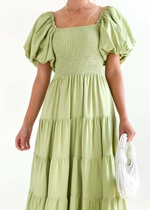Detail of light green puff sleeve dress featuring elastic smocked waist and cotton texture