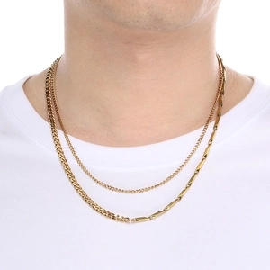 Close-up of layered gold Cuban link chains styled on a white T-shirt for men