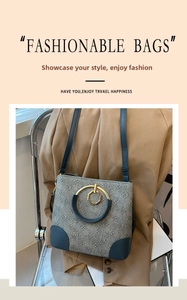Detail of grey jacquard bucket bag with monogram print and golden circular metal handle