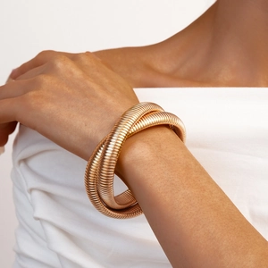 Detail of gold spiral snake-bone bracelet with textured multi-layer wrap design