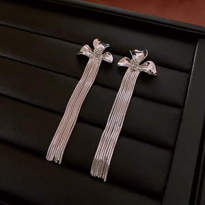 Detail shot of silver flower earrings with long fringe tassels on black leather jewelry box