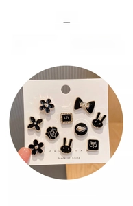 Detail view of a 10-piece black and gold mini brooch set with pearls and rhinestones