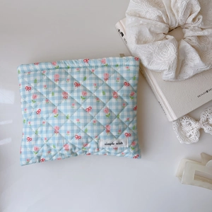 Détail du tissu matelassé en coton bleu à fleurs avec étiquette brodée simple wish