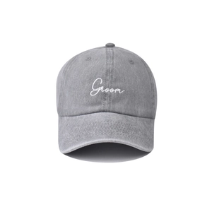 Close-up of white Groom embroidery on washed grey cotton vintage baseball cap