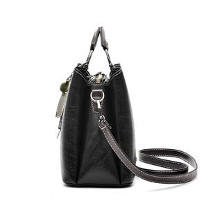Minimalist black retro handbag with brown straps and white stitching for summer 2025