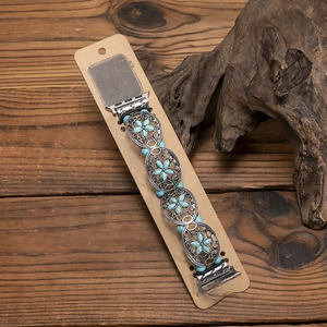 Detail of silver alloy watch band with turquoise beads on vintage wood background