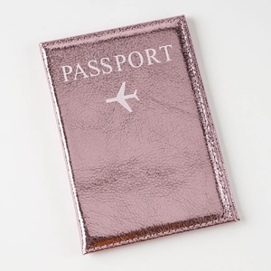 Close-up of rose gold crackle leather passport cover with white embossed text