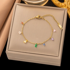 Detail of a 18K gold plated bracelet with colorful rainbow charms on a jewelry box