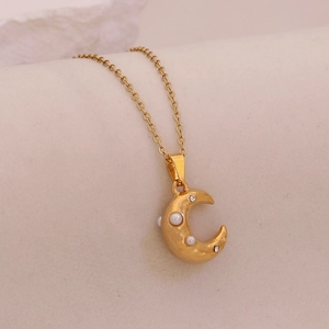 Detail of a golden moon pendant necklace featuring elegant pearls and sparkling rhinestones