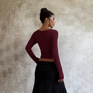 Detail of burgundy long sleeve crop top featuring slim fit design and deep scoop neckline