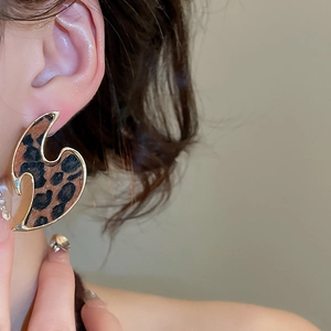 Close-up of vintage leopard print circular drop earrings with gold metallic edges
