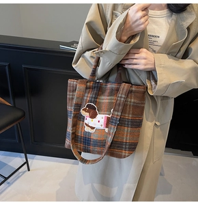 Detail of wool plaid tote bag with cute dog embroidery patch and durable handles
