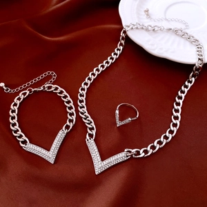 Detailed close-up of V-shaped silver jewelry set with crystals on red satin backdrop