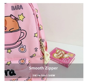 Close-up of a smooth zipper and cartoon capybara print on a pink fabric school bag