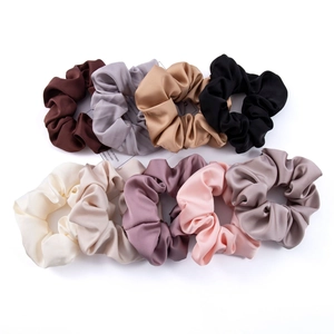 Detailed macro view of a 9-piece set of premium silk satin scrunchies in diverse colors