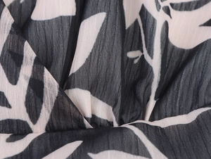Macro detail of breathable black and white leaf print chiffon fabric with mesh texture