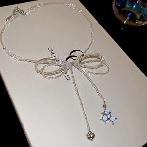 Stainless steel beaded bow necklace with heart pendant on an elegant gift box