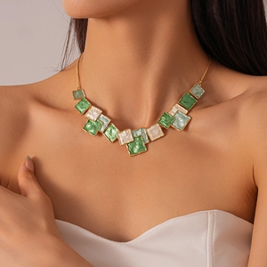 Detail of vintage gold necklace featuring green and pearl white enamel geometric squares
