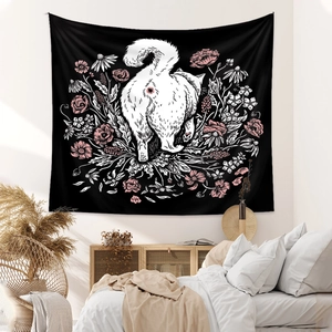 Detail of bohemian black wall tapestry featuring a white cat walking into flowers