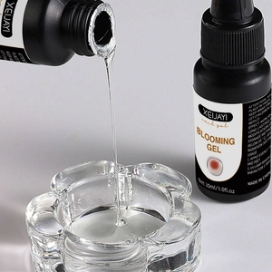Clear blooming gel liquid pouring into a glass container for professional nail art effects