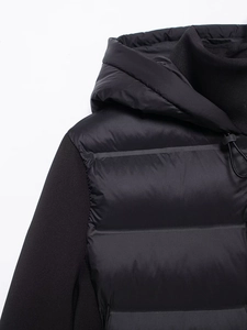 Detail of hood drawstrings and contrast sleeve stitching on black padded jacket