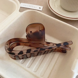 Close-up of leopard print hair claw clip on a tray with a warm lifestyle aesthetic