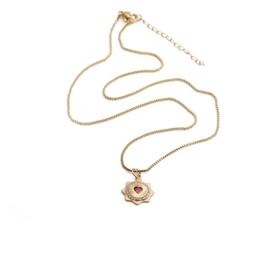 Detail view of sunflower necklace with red heart stone and lobster clasp on gold chain