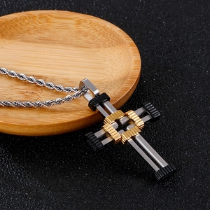 Detail of tri-color punk cross pendant in silver gold and black with rope chain