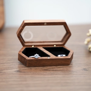 Close-up of hexagonal walnut jewelry box with glass top and black velvet interior