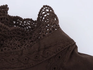 Detailed close-up of dark brown crochet lace and hollow knitted texture on the cotton top