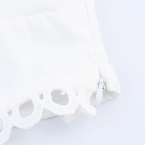 Blouse élégante en dentelle blanche avec manches bouffantes et broderie ajourée