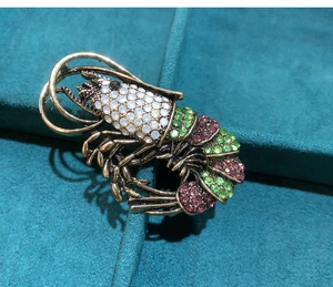 Detailed macro shot of vintage gold lobster brooch with colorful sparkling rhinestones
