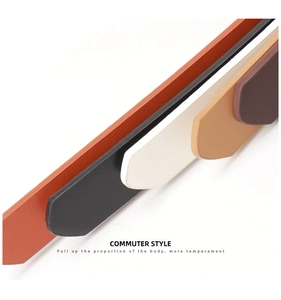 Detail of multiple color faux leather belts with polished metal buckles in a macro view