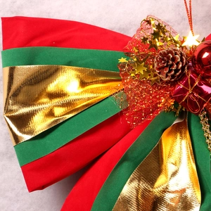 Festive red and green Christmas bow ornament with gold stars, pinecones and mini gift boxes