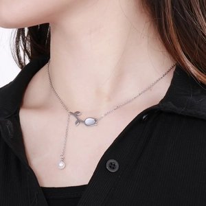 Gros plan du collier tulipe avec nacre blanche et perle ronde sur une chaîne en argent fin