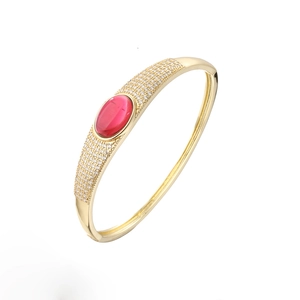 Luxurious gold-plated open bangle featuring a red oval stone and micro-pave crystals