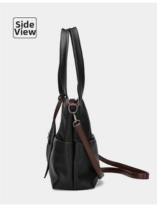 Side view of large black tote bag featuring brown straps and a practical side pocket