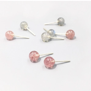Macro detail of round strawberry quartz and moonstone silver stud earrings with pins
