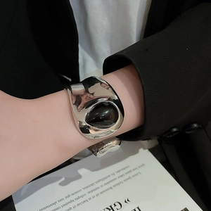 Detail of silver lava texture cuff bracelet with a black teardrop inset on a model