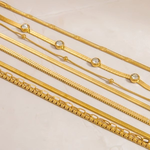 Detailed flat lay of assorted 18K gold-plated stainless steel chains with zircon accents