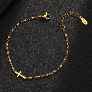 Detailed close-up of a gold stainless steel cross bracelet with pink round beads and lobster clasp