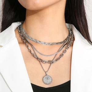 Detail of layered silver butterfly and bee coin pendant necklaces on a white suit model