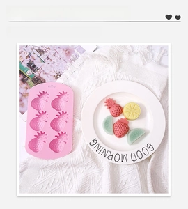 Detail of pink silicone mold with pineapple shapes and colorful fruit-shaped crafts