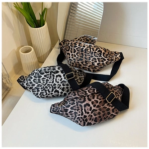 Detailed overhead view of three leopard print crossbody bags in various colors on a desk